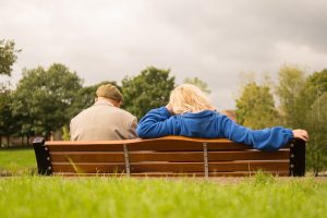 Elderly Couple sitting at a bench in a park